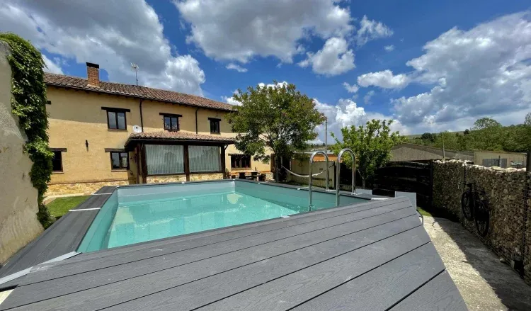 Piscina exterior con solárium de madera y zona de relax