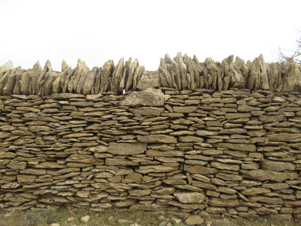 Muro rematado por losas verticales para impedir el paso de lobos o la huida de las ovejas.