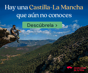Un hombre está sentado en una cornisa rocosa con vistas a un extenso paisaje montañoso bajo un cielo azul. El texto en español anima a descubrir Castilla-La Mancha.