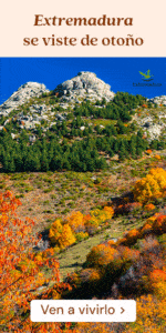 Una montaña rocosa con pinos verdes y un follaje otoñal de colores vivos. Texto en español: «Extremadura se viste de otoño. Ven a vivirlo». Logotipo de Turismo de Extremadura en el cielo.