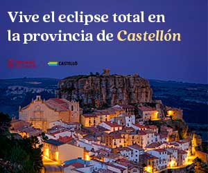 Vista de un pintoresco pueblo con casas de tejados anaranjados y una iglesia, situado bajo una colina rocosa al atardecer. El texto en español dice: Vive el eclipse total en la provincia de Castellón.