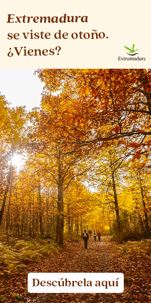 Unas personas caminan por un sendero forestal rodeado de árboles con hojas otoñales de vivos colores. Un texto en español invita a los lectores a visitar Extremadura en otoño. En una esquina aparece el logotipo de Extremadura.
