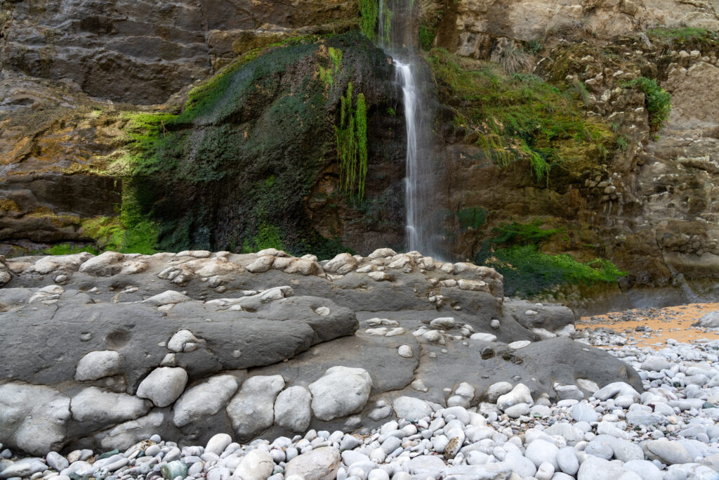 Cascada que acaba en la arena de la playa de Covachos, en Santa Cruz de Bezana. Por JoseLuis