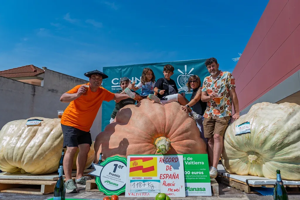 Rubén Mendi celebra junto a su familia el récord de España de calabazas gigantes que consiguió en el concurso de Valtierra (Navarra).