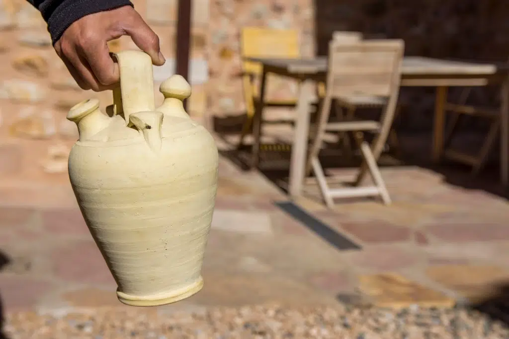 Una persona lleva un botijo. Por pedro