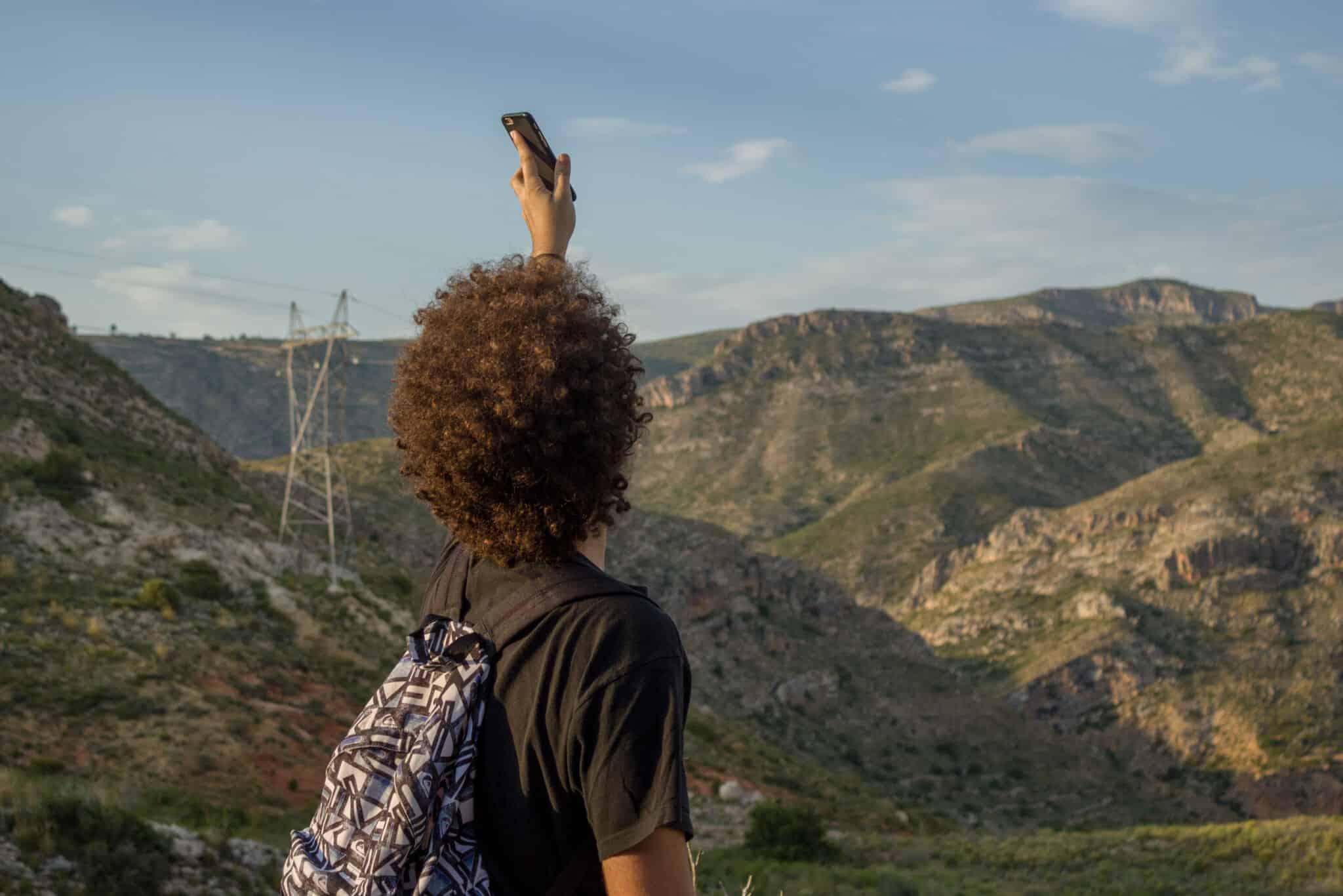 Una persona con el teléfono móvil en la montaña. Por Adrián