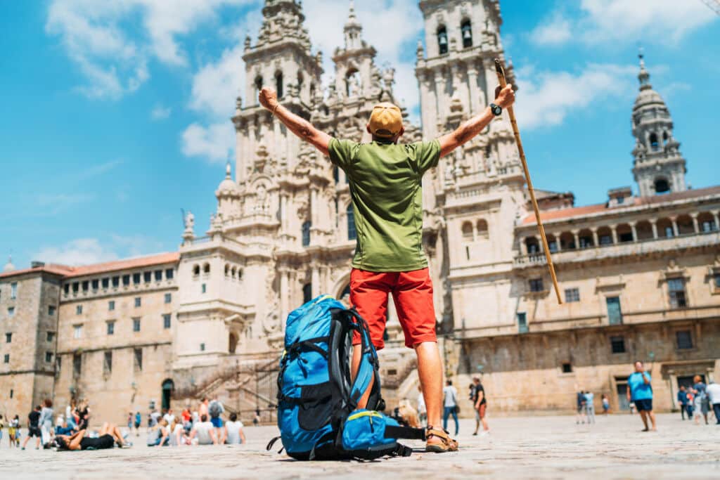 Peregrino celebrando la llegada a la plaza del Obradoiro, en Santiago de Compostela (A Coruña).