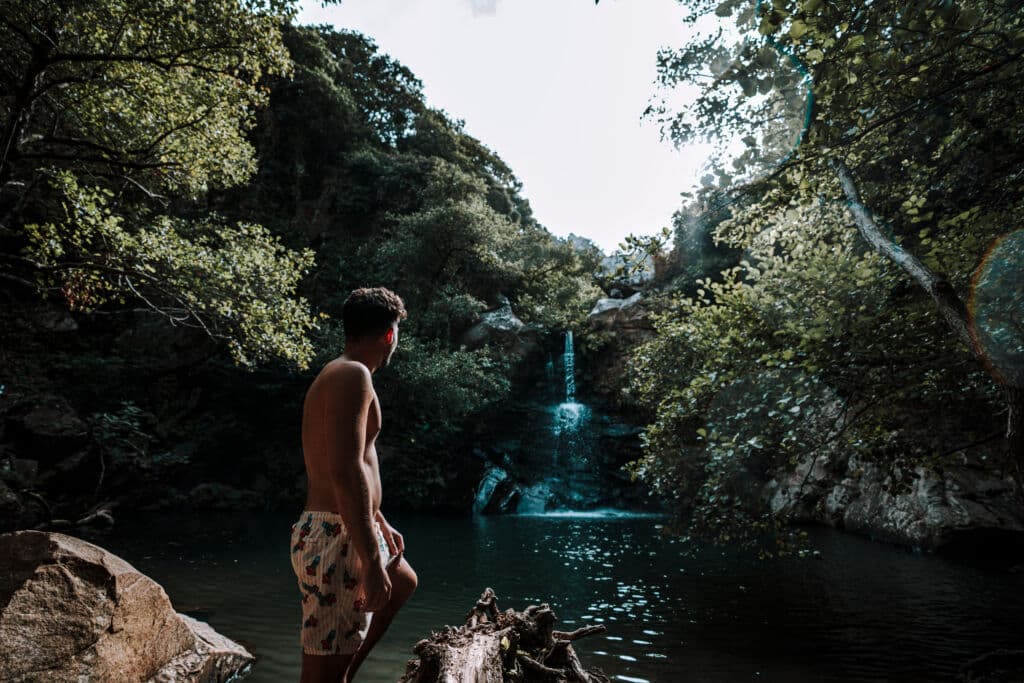Un chico observa la cascada de la Garganta del Capitán de Cádiz, en verano. Por MiguelAngelJunquera