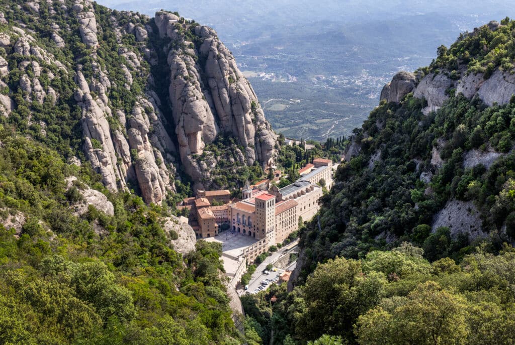 La abadía de Santa María de Montserrat, enclavada en un profundo valle rocoso de montaña.