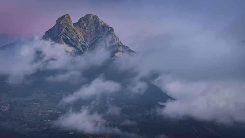 Pedraforca in a summer sunrise with low clouds over the Saldes Valley, seen from near La Palomera (Berguedà, Catalonia, Spain, Pyrenees)